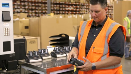Distribution center Supervisor looking at barcode scanner
